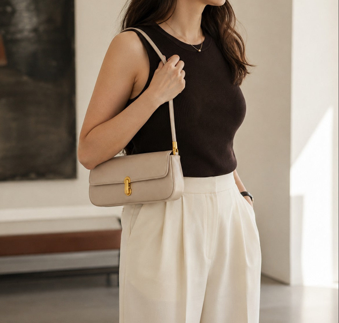 VALENORA Bianca cream microfiber leather shoulder bag with gold link clasp worn by a woman in a dark tank top