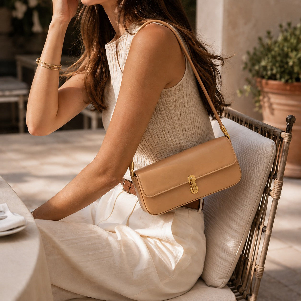 VALENORA Bianca cream microfiber leather shoulder bag with gold link clasp worn by a woman in a neutral outfit.
