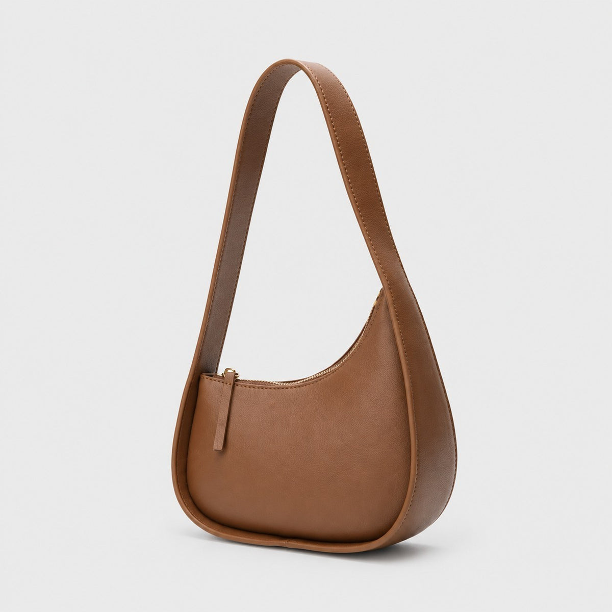 VALENORA Brooklyn shoulder bag in caramel genuine leather with a crescent silhouette and gold-tone zipper closure.