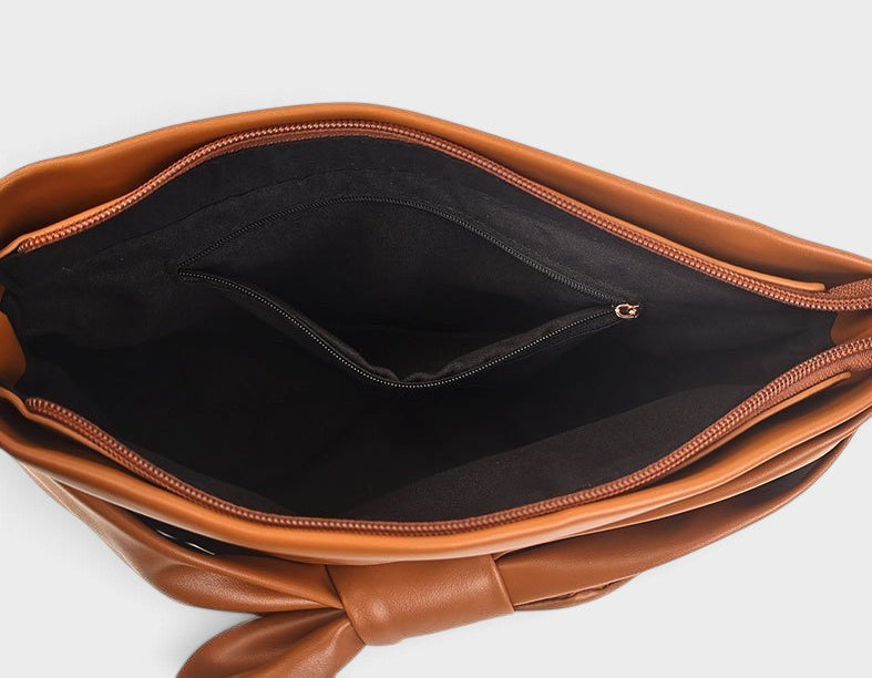 VALENORA brown leather handbag interior with a zippered pocket and a decorative bow detail on the front