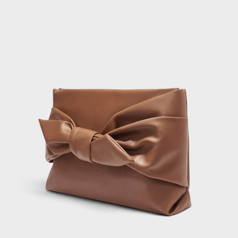 VALENORA brown leather handbag featuring a prominent decorative bow detail on the front in a structured design