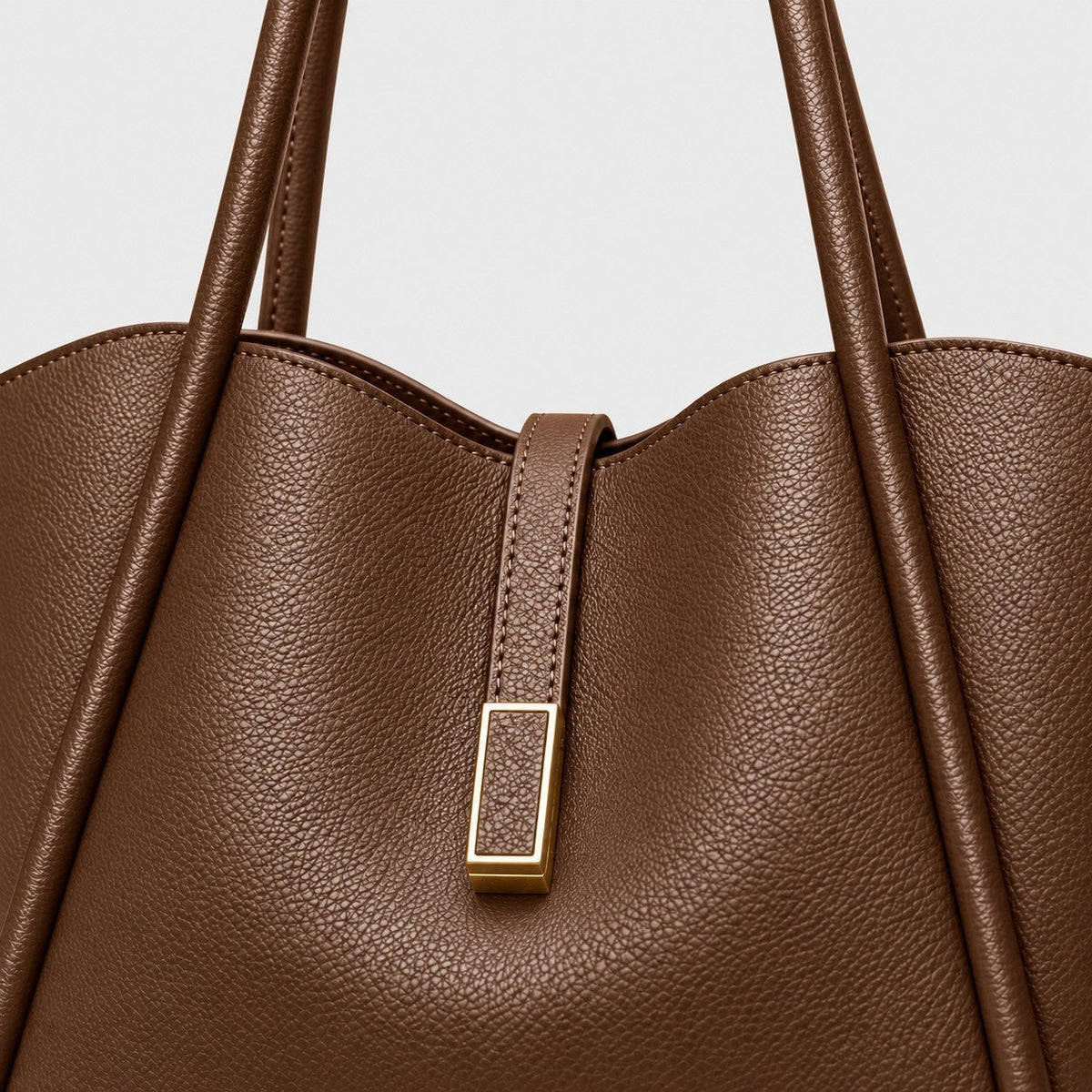 VALENORA Charlotte tote bag in brown litchi-grain vegan leather with a gold hardware tab and curved top edge