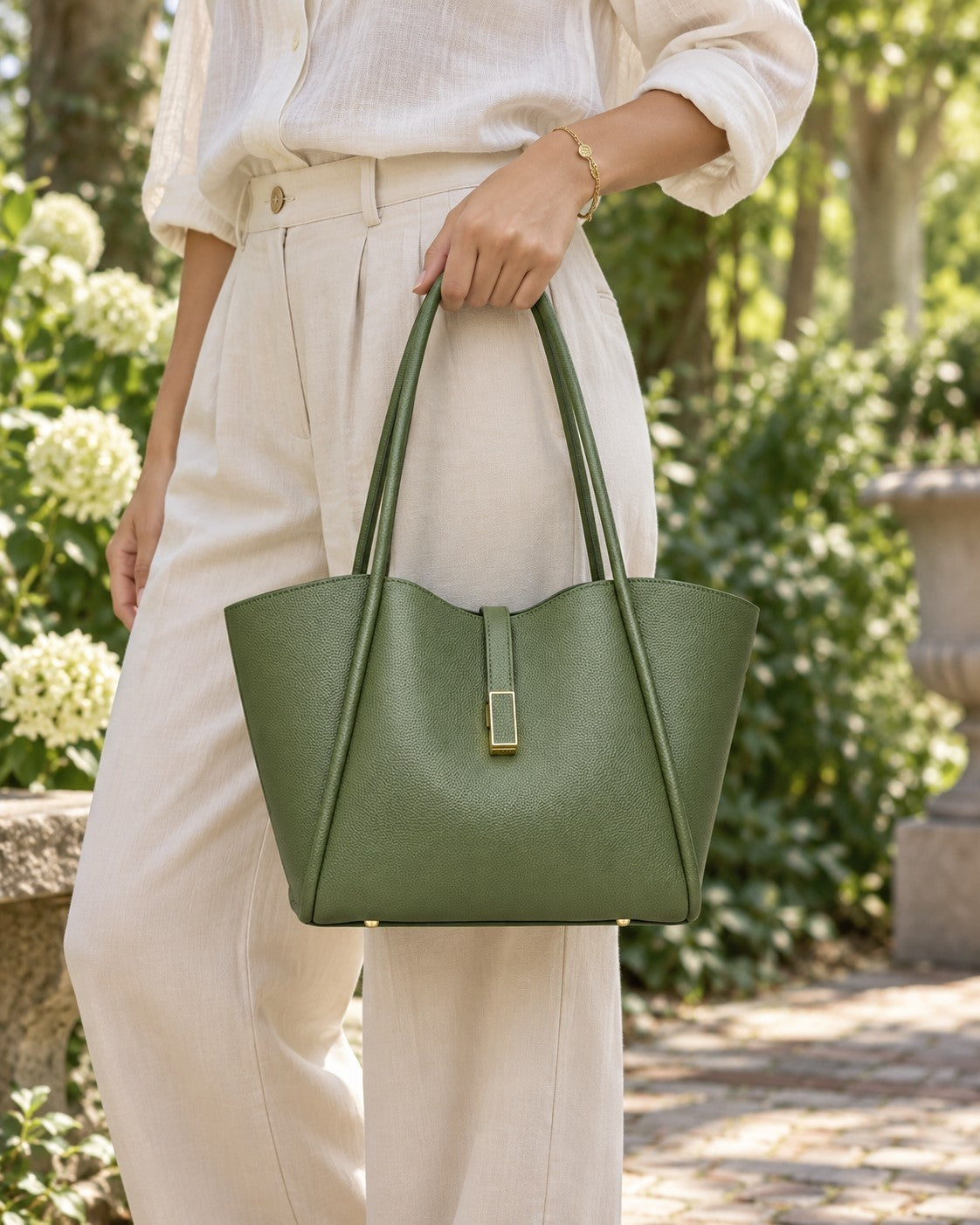 VALENORA Charlotte tote bag in olive green vegan leather with litchi-grain texture and gold hardware held by a woman