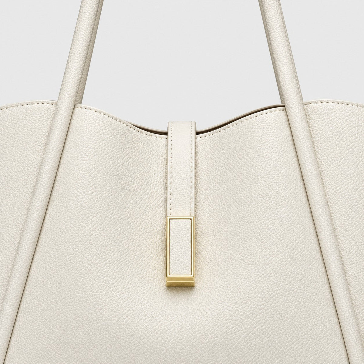 VALENORA Charlotte tote bag in off-white litchi-grain vegan leather with a gold rectangular hardware tab detail.