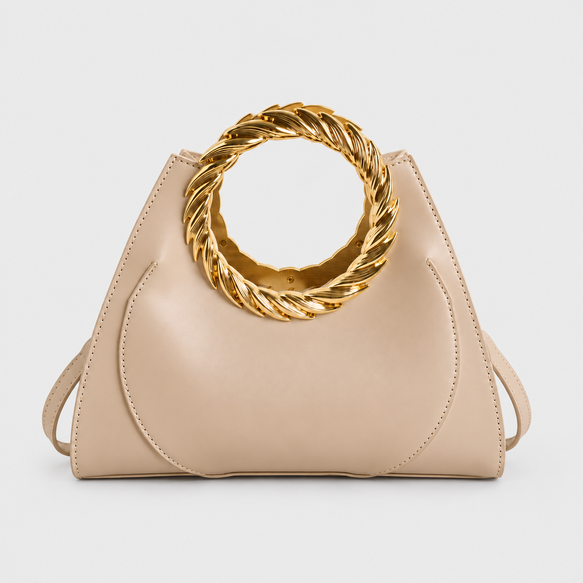 VALENORA Cleo handbag in beige vegan leather with a bold, twisted gold ring handle and tapered silhouette.