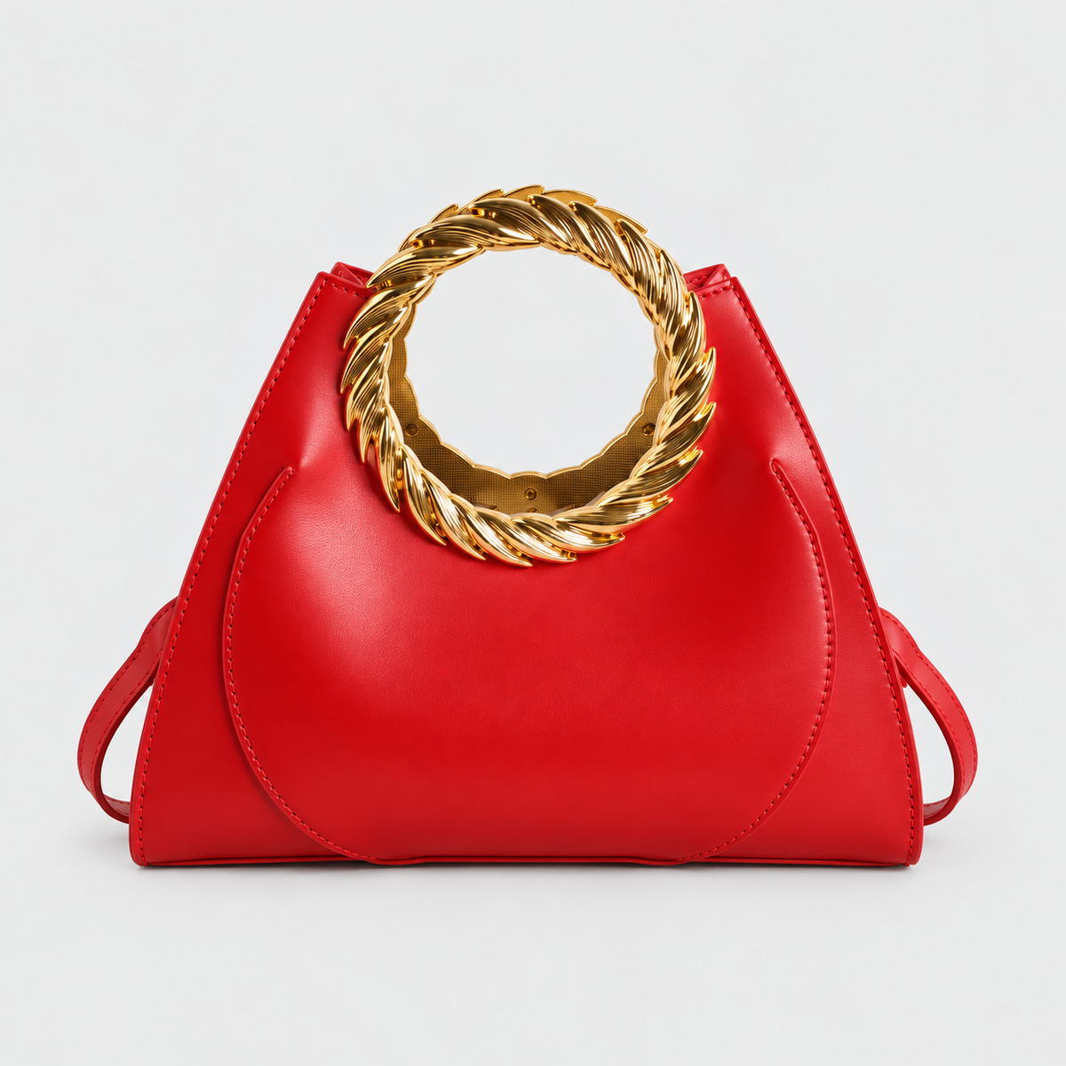 VALENORA Cleo red vegan leather handbag featuring a bold rope-twisted gold ring handle and tapered silhouette.