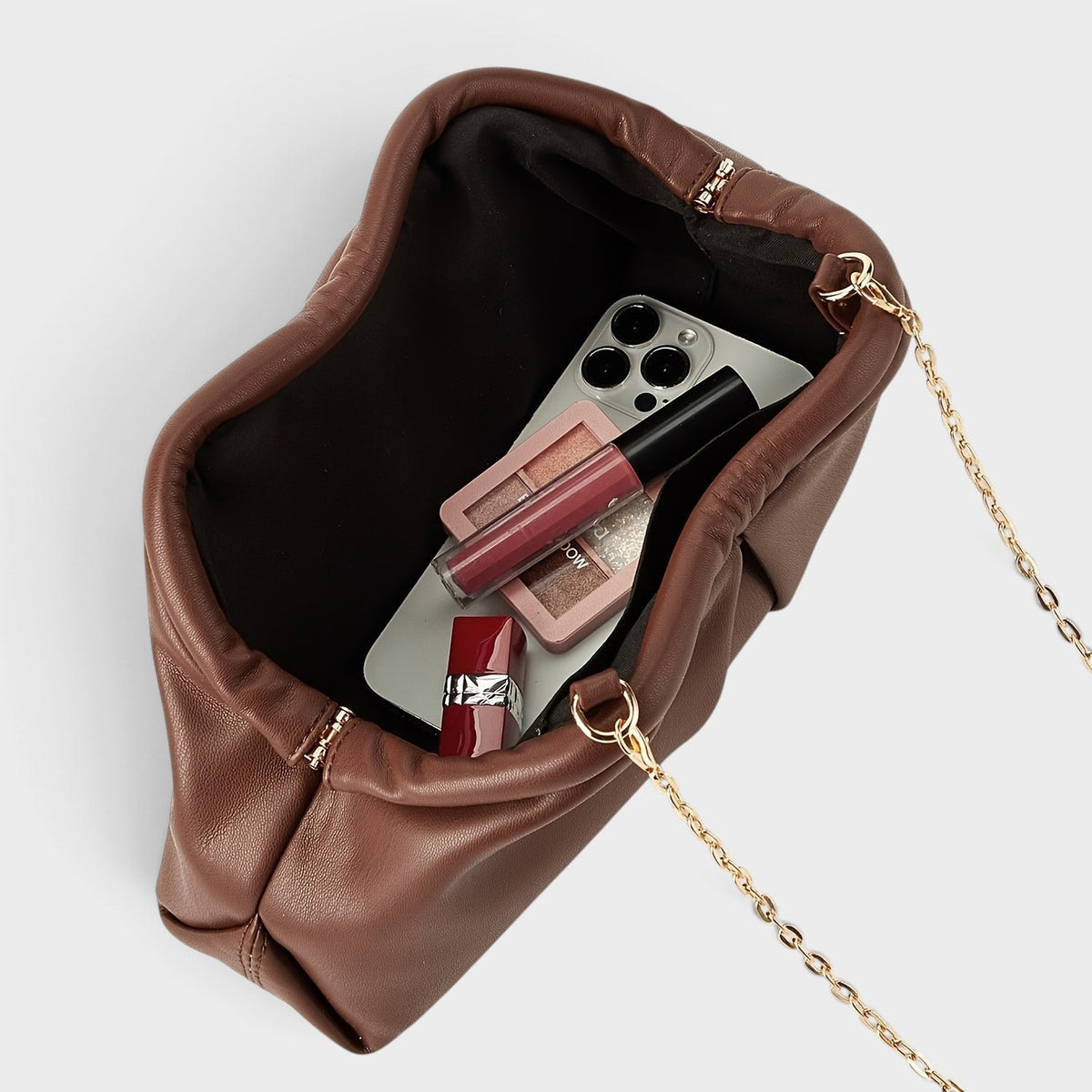 VALENORA Colette clutch bag in brown vegan leather with pleated design, gold chain strap, and interior essentials.