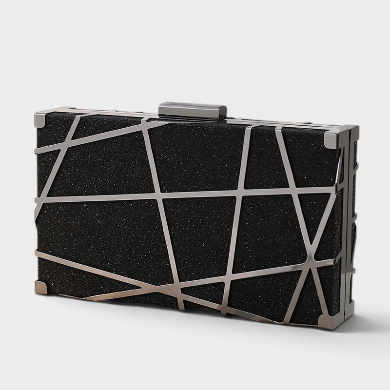 VALENORA geometric clutch in black with a metallic silver angular overlay for an evening look.