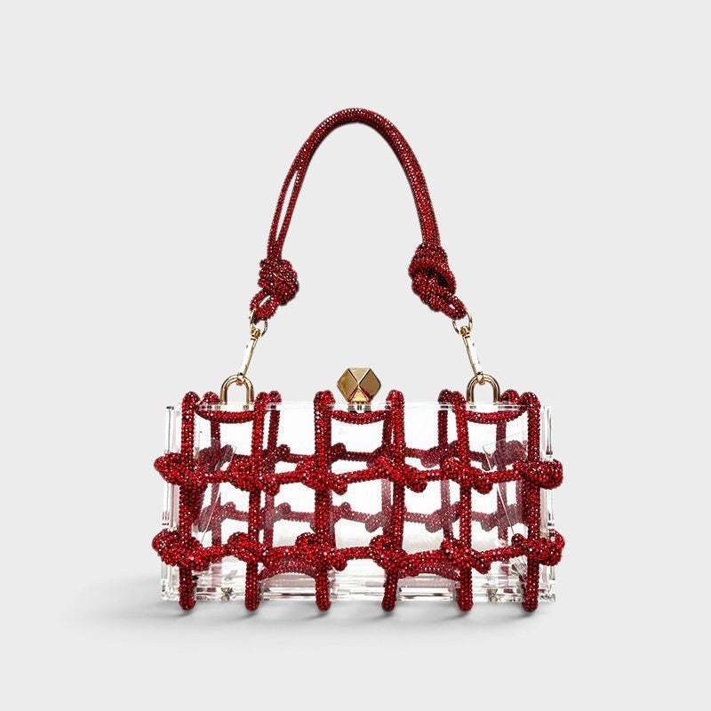 VALENORA Isabelle transparent acrylic clutch bag with a red crystal-embellished grid overlay and matching top handle.