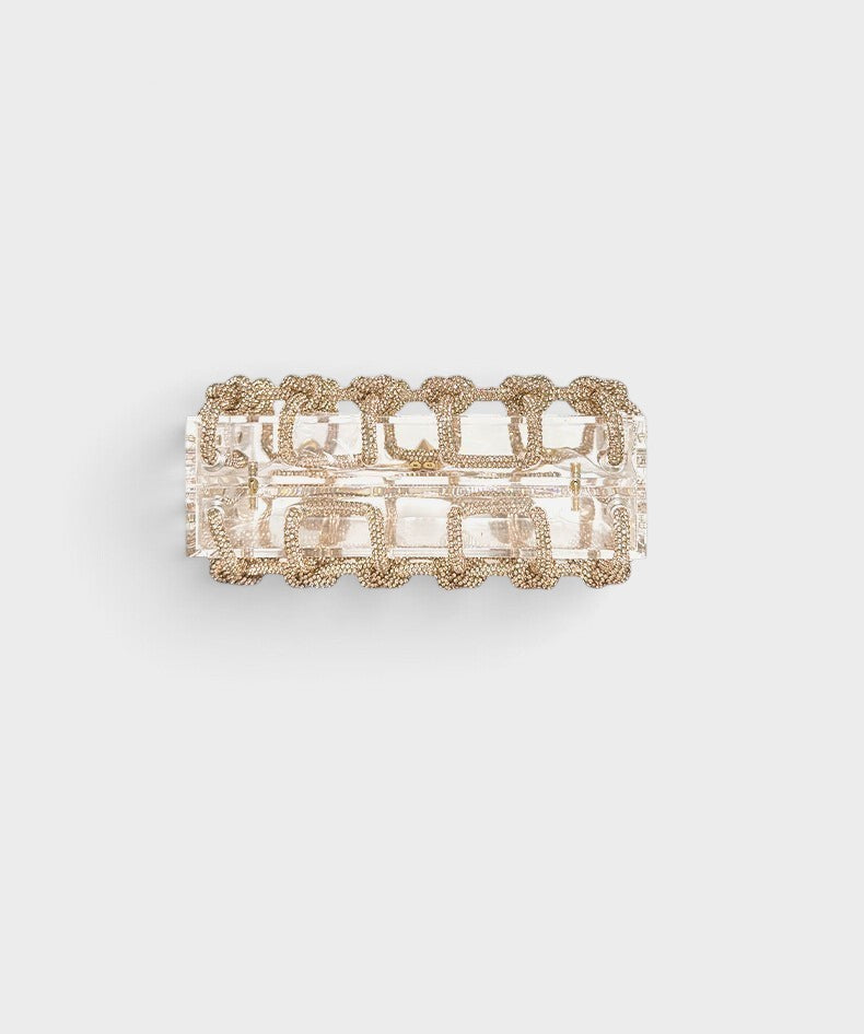 VALENORA Isabelle transparent acrylic clutch bag with decorative gold chain trim detail viewed from above