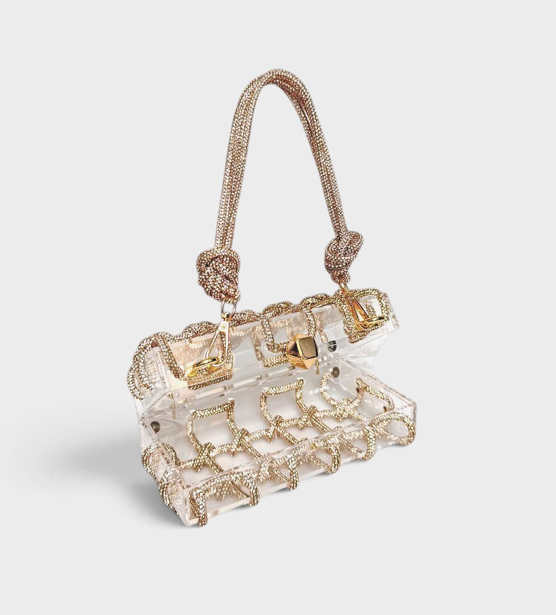 VALENORA Isabelle transparent acrylic clutch bag with gold rhinestone embellished handle and decorative trim