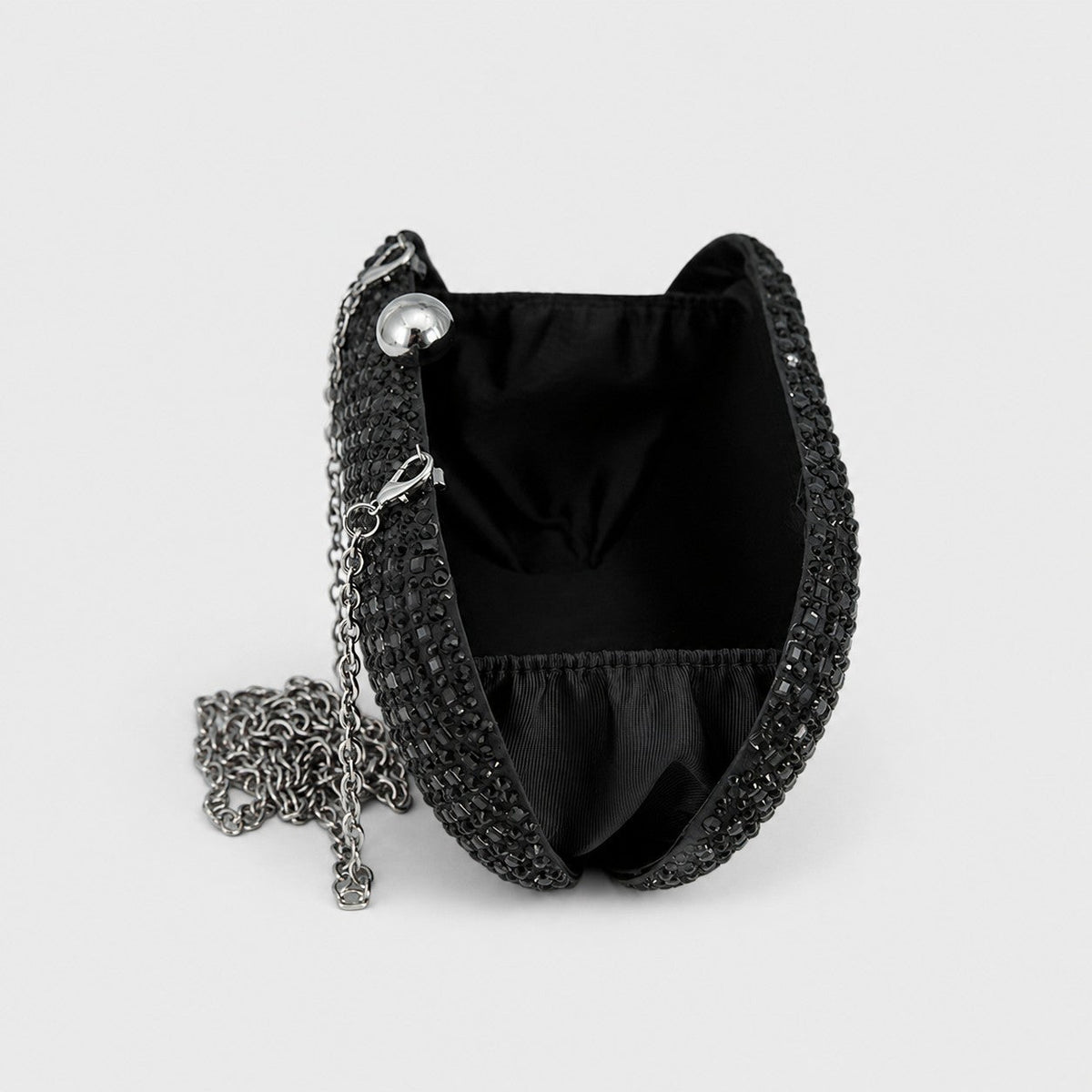 VALENORA Ismay black crystal clutch bag with silver ball clasp and detachable chain strap, open interior view.