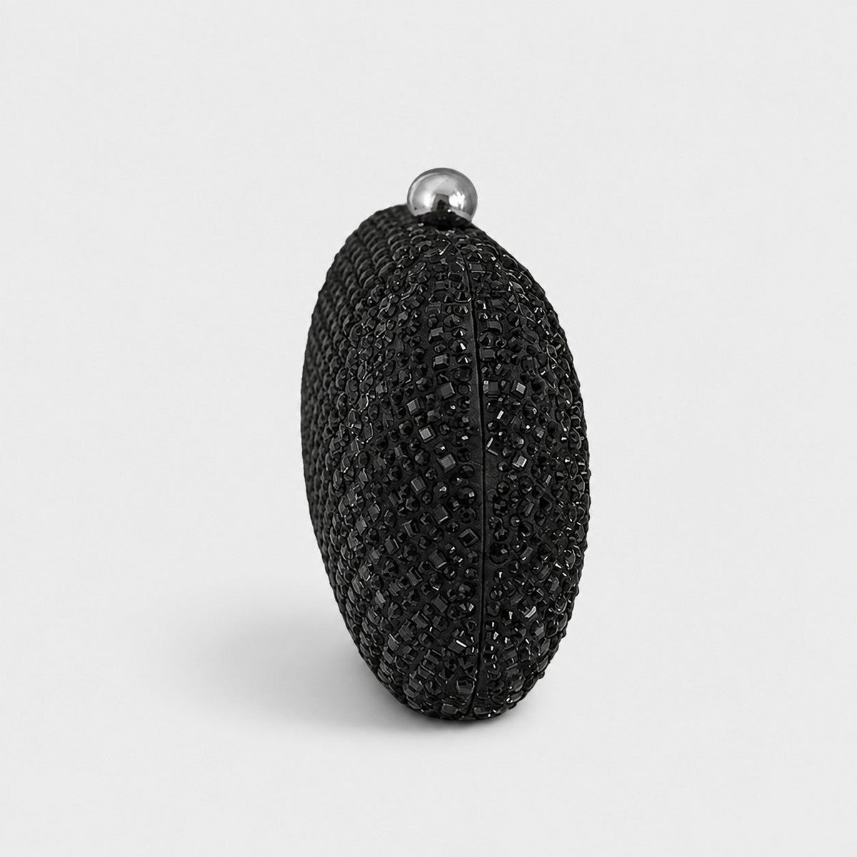VALENORA Ismay oval clutch bag covered in black crystals with a polished silver-tone ball clasp closure