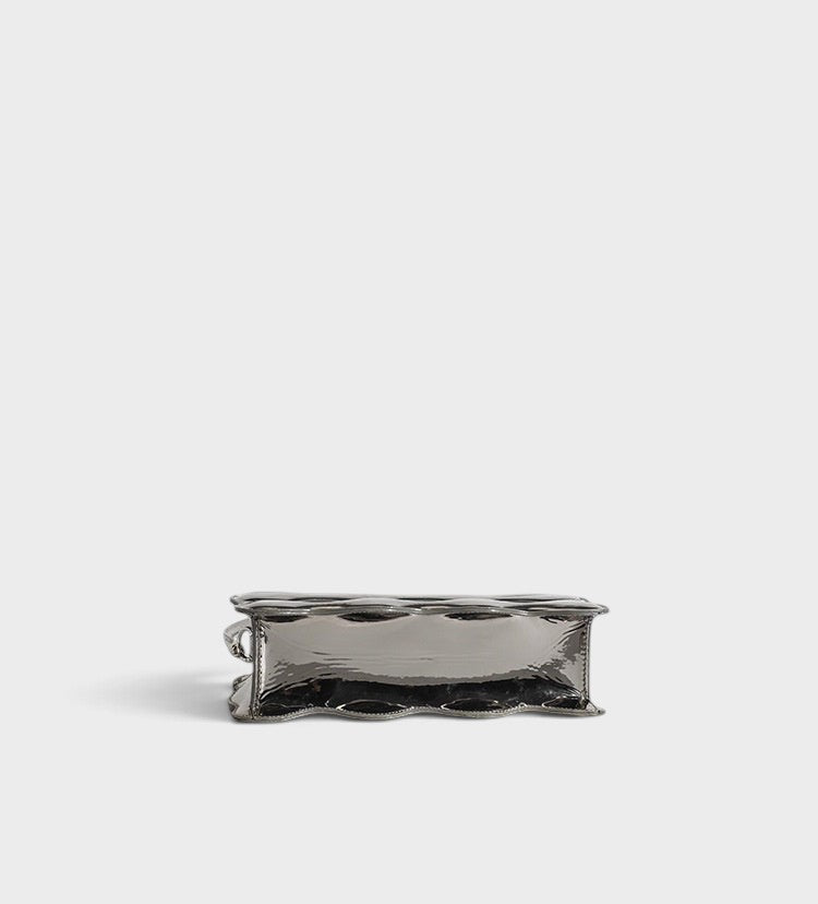 VALENORA Luna Wave shoulder bag in metallic silver vegan leather with a unique sculptural curved base