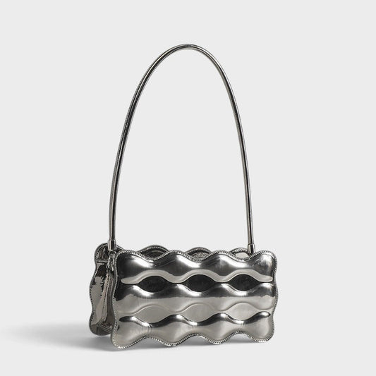 VALENORA Luna Wave shoulder bag in metallic silver vegan leather with a unique sculptural curved silhouette.