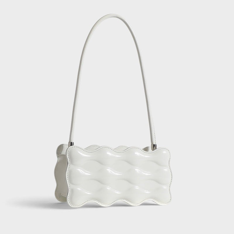 VALENORA Luna Wave shoulder bag in white vegan leather with a unique sculptural curved silhouette.