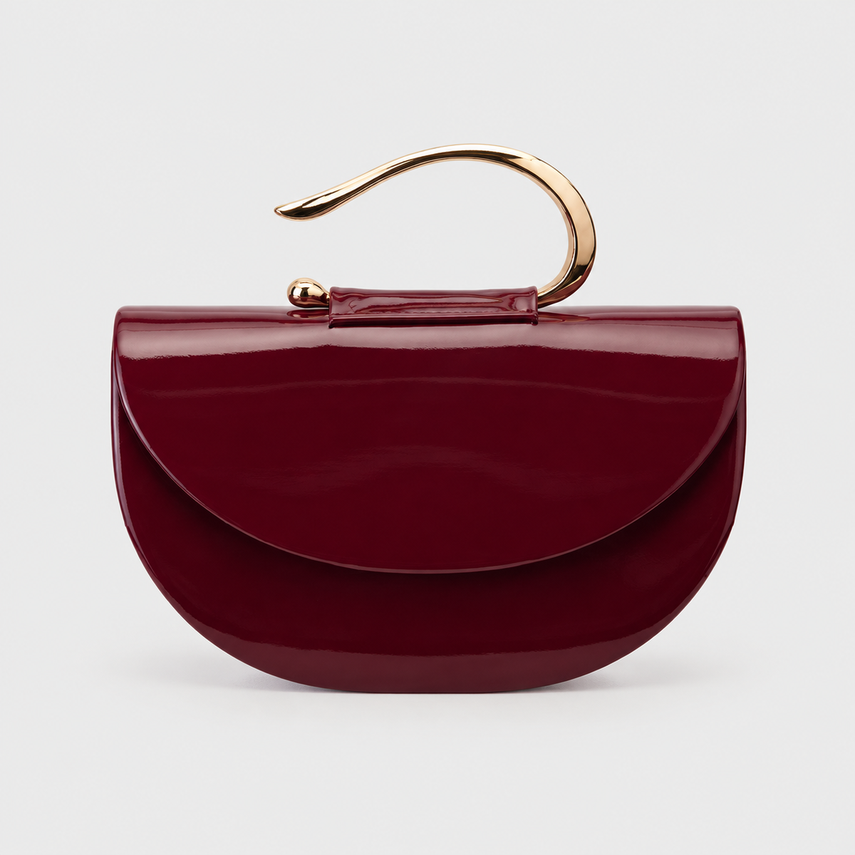 VALENORA Luna handbag in wine red vegan leather with a glossy finish and a unique sculpted gold curved handle.
