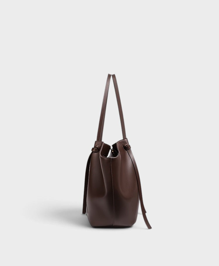 VALENORA Madison leather tote bag in burgundy with a sculptural knotted top handle, side view.
