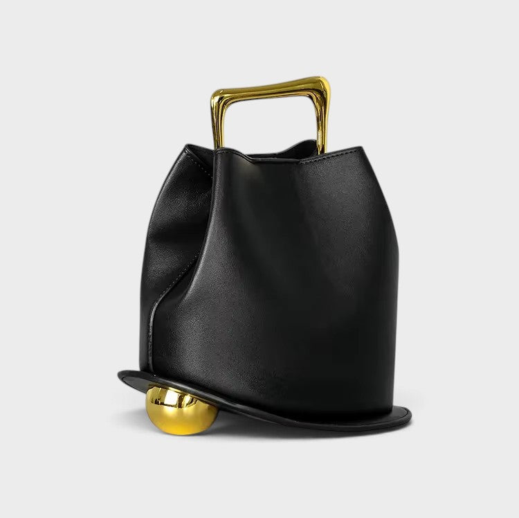 VALENORA Marisol handbag in black with a sculptural silhouette, gold-toned metallic handle, and spherical base detail.