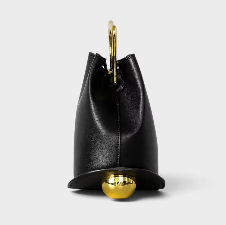VALENORA Marisol handbag in black with a sculptural silhouette, gold-toned metallic handle, and spherical base detail.