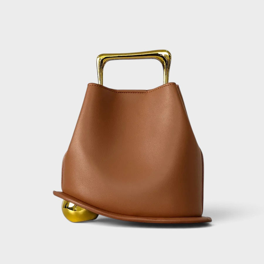 VALENORA Marisol handbag in brown with a sculptural silhouette, gold-toned metallic handle, and spherical base detail.