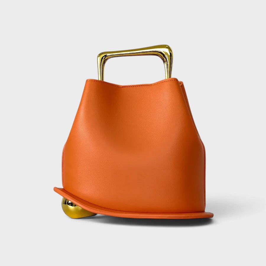 VALENORA Marisol handbag in vibrant orange with a sculptural silhouette, gold-toned metallic handle, and spherical base.