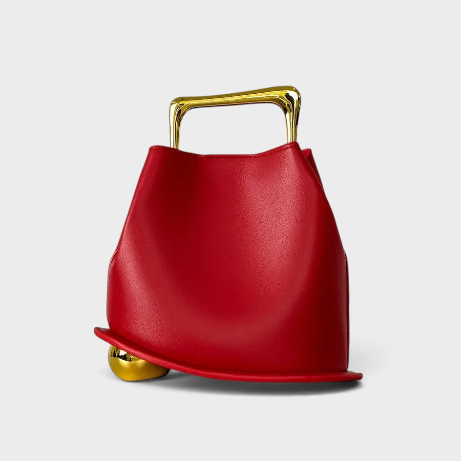 VALENORA Marisol handbag in vibrant red with a sculptural silhouette, gold-toned metallic handle, and spherical base.