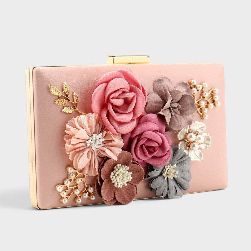 VALENORA Rosalind clutch bag in soft pink with fabric flowers, pearl accents, and gold-tone leaf detailing.