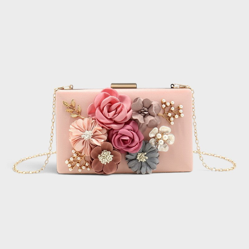 VALENORA Rosalind clutch bag in blush pink with fabric floral embellishments, pearl accents, and gold chain strap.