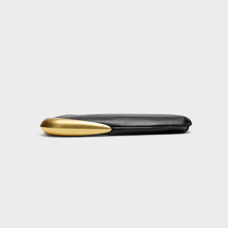 VALENORA Rosanna shoulder bag in black with a sleek curved profile and a striking metallic gold side accent.