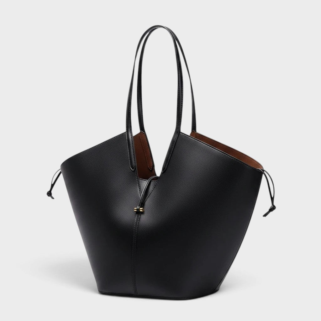 VALENORA Solene black vegan leather tote bag with a sculptural wraparound handle and gold toggle detail.