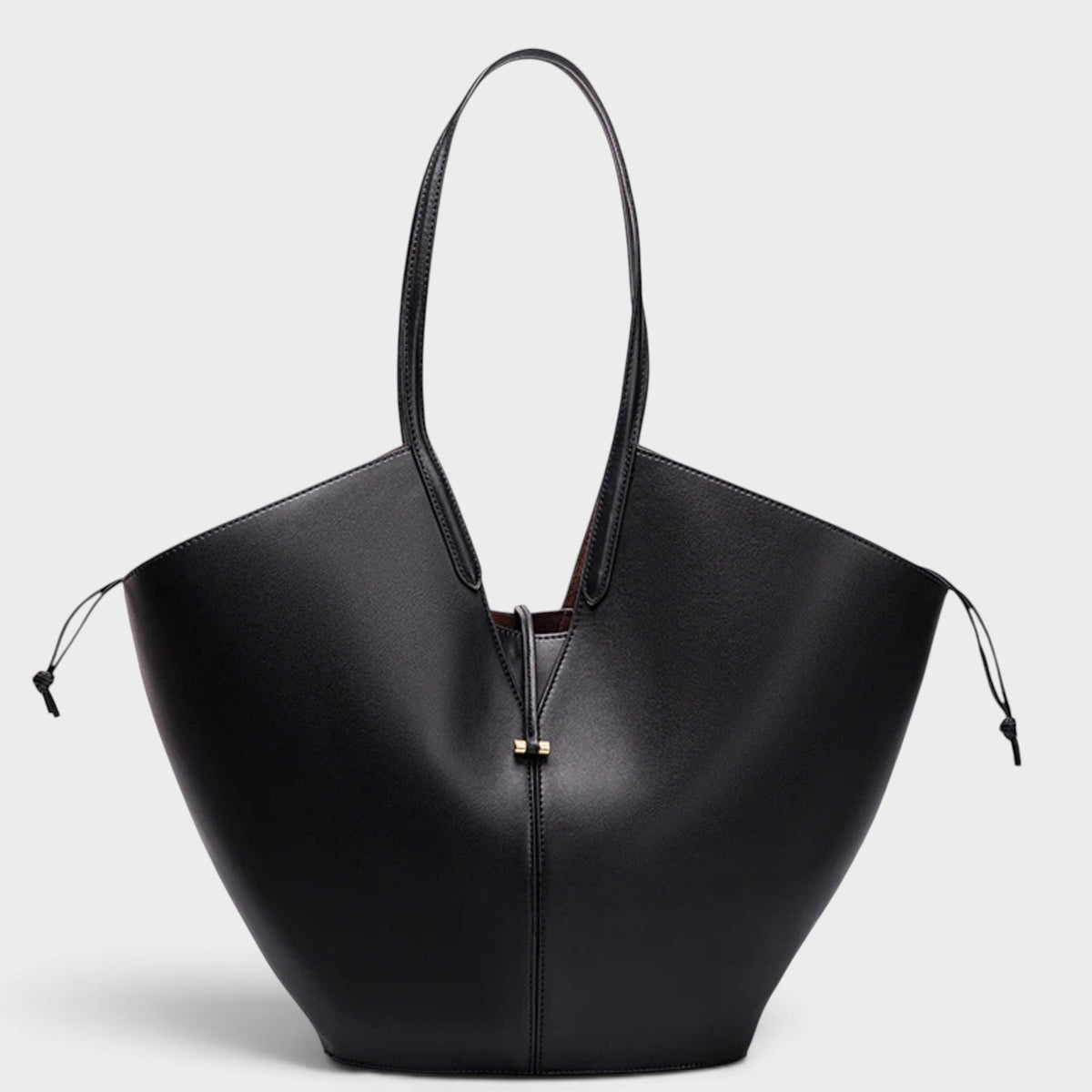 VALENORA Solene black vegan leather tote bag with a sculptural wraparound handle and small gold front toggle detail.