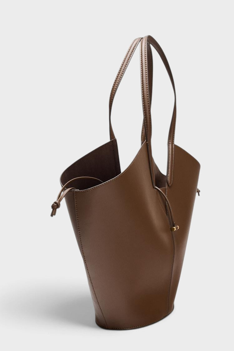 VALENORA Solene brown vegan leather tote bag with a sculptural wraparound handle and gold toggle detail
