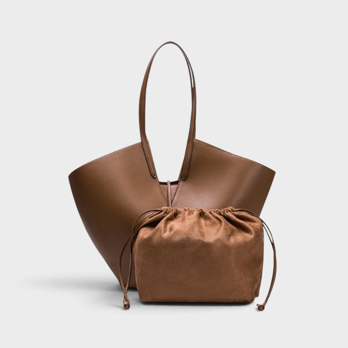 VALENORA Solene brown vegan leather tote bag with a sculptural wraparound handle and a matching drawstring pouch.