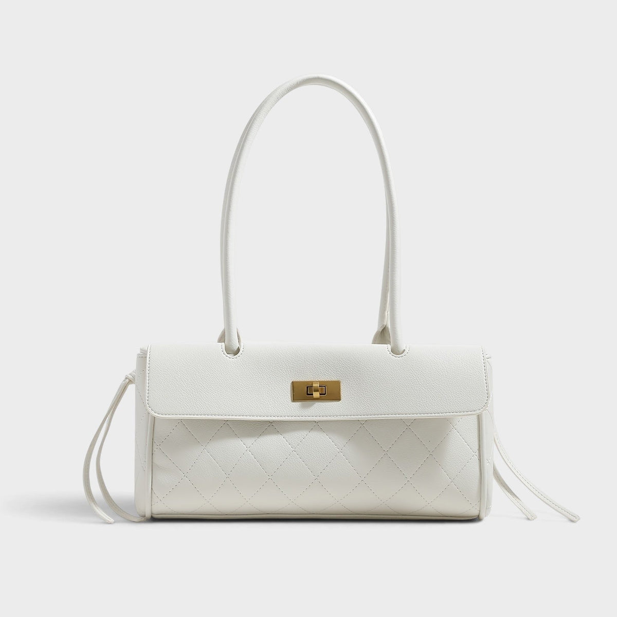VALENORA white quilted shoulder bag with gold turn-lock closure and side-tie details on a clean background.