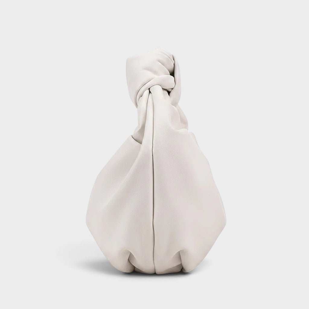 VALENORA white vegan leather handbag with a soft, knotted handle and a minimalist matte finish.