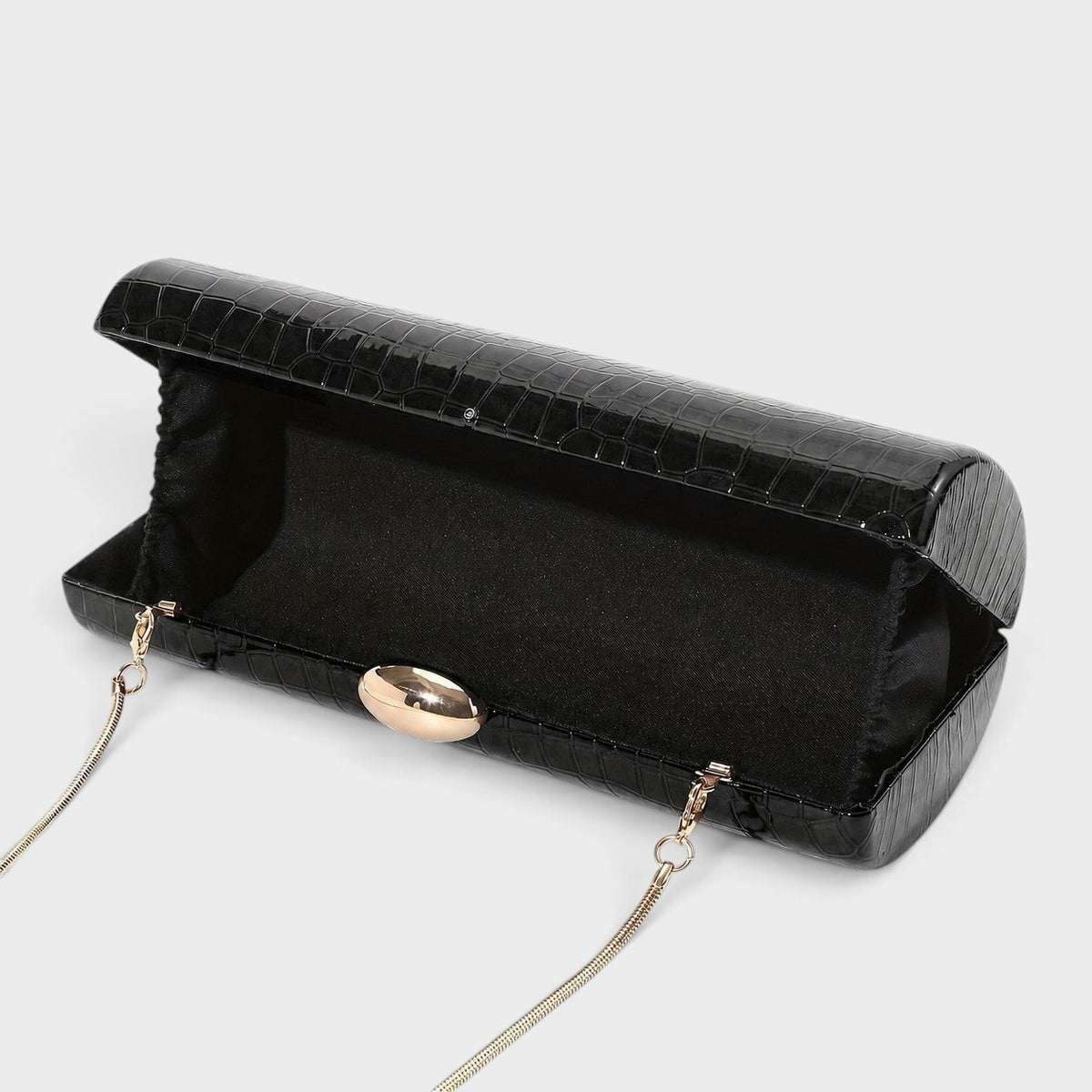 VALENORA Ysabel black croc-embossed vegan leather cylindrical clutch with a gold ball clasp and detachable chain strap.